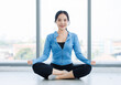© Bangkok Click Studio - Asian young beautiful happy woman fit sporty slim healthy in sportswear practicing sitting yoga in lotus pose feeling contemplation meditating while training in bright fitness gym wellness lifestyle.