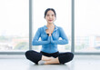 © Bangkok Click Studio - Asian young beautiful happy woman fit sporty healthy in sportswear practicing sitting on floor in yoga lotus position feeling contemplation meditation training in bright fitness gym wellness lifestyle