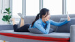© Bangkok Click Studio - Asian young beautiful happy woman fit sporty active healthy in sportswear lay down on cozy sofa using mobile smartphone after workout exercise training in bright living room studio wellness lifestyle.
