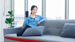 © Bangkok Click Studio - Asian young beautiful cheerful happy smile woman activewear fitness outfit sitting cozy sofa holding mobile smartphone with blank black screen showing in bright living room healthy wellness lifestyle.
