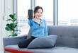 © Bangkok Click Studio - Asian young beautiful cheerful happy smile woman activewear fitness outfit sitting cozy sofa holding mobile smartphone with blank black screen showing in bright living room healthy wellness lifestyle.