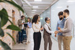 © anatoliycherkas - Business people meeting in office hallway, collaborating and shaking hands for partnership, startup teamwork concept