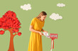 © Pixel-Shot - Surprised young woman taking paper letter from mailbox near decorated green wall. Valentine's Day celebration