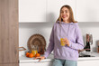 © Pixel-Shot - Young woman with glass of orange juice in kitchen