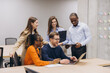 © anatoliycherkas - Diverse professionals collaborating, sharing creative insights during laptop centered meeting in modern workplace environment