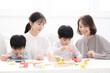 © kapinon - 祖母と母と子どもが笑顔で積み木で遊ぶ三世代家族、親子の幸せなイメージ　子ども(孫)2人