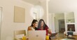 © vectorfusionart - Working two adult women sharing tablet and viewing silver laptop at dining table with orange juice
