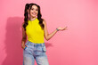 © deagreez - Young chic female model in bright yellow top and jeans poses happily against pink background