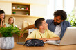 © djile - Father helping son with homework at kitchen table
