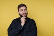 © bodnarphoto - Thoughtful man with beard smiling and looking to the side against a yellow background during daytime