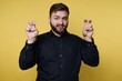 © bodnarphoto - Man makes gesture with fingers in front of bright yellow background while wearing a black shirt
