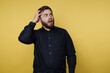 © bodnarphoto - Man with beard looks surprised while standing against yellow background at indoor location during daytime