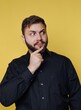 © bodnarphoto - Man shows thoughtful expression while standing in front of yellow background