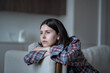 © ingoodtime - Disinterested bored woman stares blankly out window feeling no motivation, lack of dopamine sits on couch. Lost in thoughts sad girl sits at home alone have low energy. Frustration, apathy, melancholy