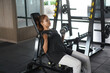 © Sino Images Studio - Focused woman performing seated incline dumbbell curls