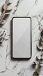 © COK House - A modern smartphone with a blank screen lies on a white marble background, surrounded by eucalyptus branches, creating an atmosphere of minimalism and cosiness — the perfect backdrop