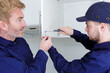 © auremar - man and apprentice in overall repairing cabinet
