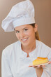 © auremar - Proud bakery worker holding a slice of flan