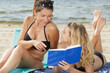 © auremar - women reading notes on the beach