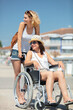 © auremar - invalid girl on the wheelchair with friend outdoors