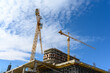 © Nannie - Crane and building construction site against blue sky