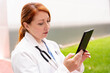 © StockMe - Female doctor in lab coat with stethoscope using a digital tablet for healthcare data and patient records