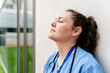 © StockMe - Overworked nurse resting outside hospital on break, feeling exhausted and experiencing professional burnout. Copy space