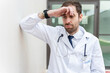 © StockMe - Male physician dealing with medical stress, fatigue, and mental exhaustion, leaning against a wall outside a hospital building