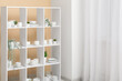 © Pixel-Shot - Modern shelving unit with clean dishware near light curtain in kitchen