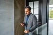 © Miljan Živković - Businessman laughing using smart phone for communication