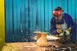 © Wavebreak Media - Senior metalworker grinding part with angle grinder sparks reflecting on visor, bench, copy space