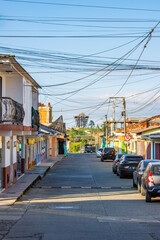 Naklejka na meble A serene street view in Filandia features colorful houses and tangled power lines under a clear blue sky.