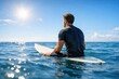 © Nadiia - Surfer sitting on surfboard in calm ocean water under bright sun enjoying peaceful summer day at sea