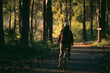 © chokniti - Bicyclist cycling through summer green forest, enjoying nature lifestyle, fitness and wellness journey, peaceful recreation and adventure in a trees park, freedom, happiness, healthy leisure travel