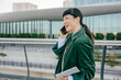 © BusinessClass by W61 - Confident businesswoman talking on mobile phone outdoors holding tablet