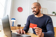 © BusinessClass by W61 - Smiling buyer making secure online payment on laptop indoors