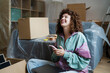© TrueShot | Westend61 - Happy woman relaxing while moving into a new home