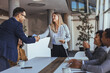 © Dragana Gordic - Business Meeting and Handshake Among Colleagues in Modern Office, Teamwork and Celebration
