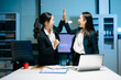 © Nuttapong punna - Two businesswomen celebrating success after achieving goals at office desk. Teamwork, motivation, leadership, startup growth and modern corporate workplace.