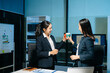 © Nuttapong punna - Two businesswomen having a friendly discussion during coffee break in modern office. Professional teamwork, collaboration, communication, startup and corporate workplace lifestyle.