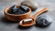 © backup_studio - Activated charcoal capsule on wooden spoon with charcoal pieces in a bowl. Natural detox medicine and dietary supplement.