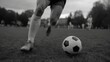 © fotogurme - Black and white soccer action on grass field, low view of athlete legs and ball in motion, energetic training vibe for sports fitness and youth league