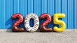 © tonstock - Vibrant 2025 donut balloon display for a new year party celebrating hope for the future.