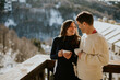 © BGStock72 - Cozy moments and warm smiles on a snowy mountain balcony with a scenic view