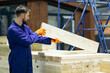 © Petro - Male worker with wooden bars for modular buildings