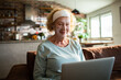 © Geber86 - Senior woman with facial mask using laptop at home