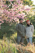 © chokniti - Couple in love enjoying nature travel, romantic relationship with happiness togetherness, smiling partners under blooming cherry blossoms, peaceful outdoor lifestyle