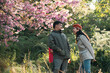 © chokniti - Couple in love enjoying nature travel, romantic relationship with happiness togetherness, smiling partners under blooming cherry blossoms, peaceful outdoor lifestyle