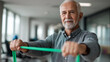 © Laura - Faceless senior hands pulling green resistance band, defocused during physical therapy session, bright rehabilitation clinic, muscle strengthening, therapeutic training, with copy