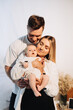 © DSMT - Cherished Family Moment Parents Heartfully Embrace Their Adorable Baby in a Beautiful and Heartwarming Portrait Capturing Love and Connection Between Family Members in a Cozy Environment
